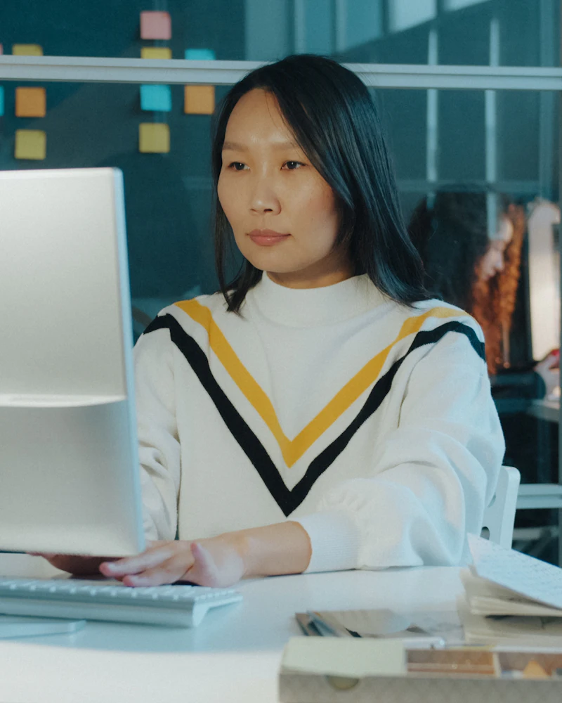Asian virtual assistant organising documents and data on a laptop