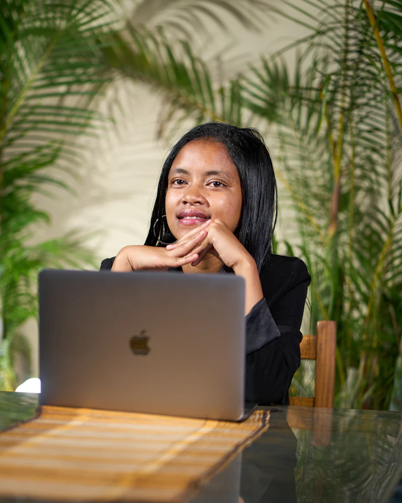 Filipina virtual assistant with a headset managing email and calendars on a laptop