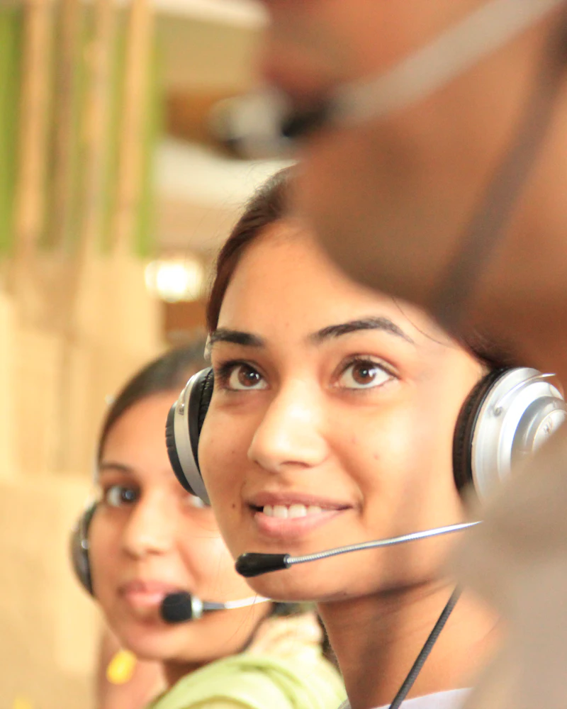 Asian customer support assistant wearing a headset at her workstation